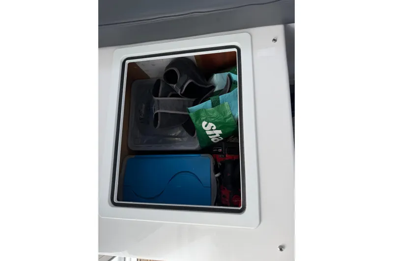 Slide: The Image of Storage compartment on 2018 H&H Marine Osmond Beal boat with various items inside. - 73