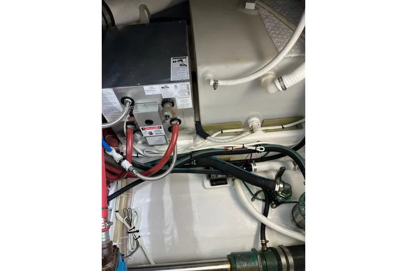 Slide: The Image of Engine compartment of a 2018 H&H Marine Osmond Beal boat, showing various hoses and components. - 97