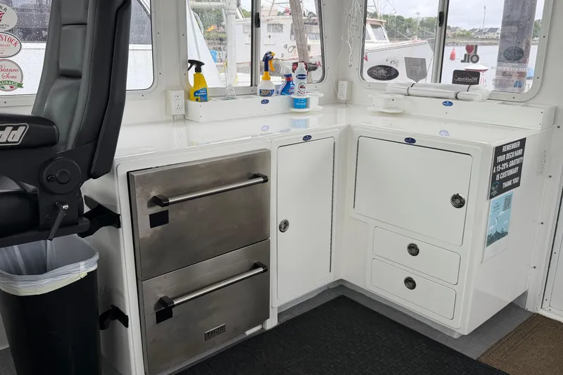 Slide: The Image of Interior of a 2018 H&H Marine Osmond Beal boat with storage and cleaning supplies. - 15