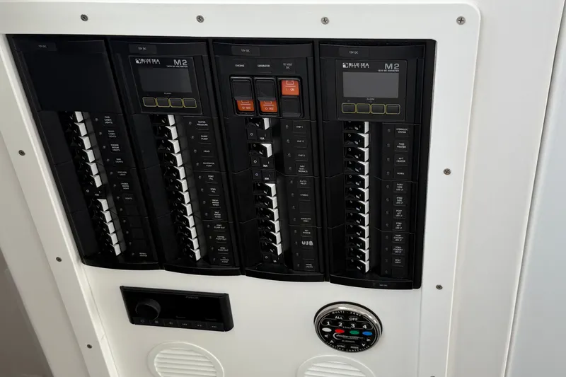 Slide: The Image of Electrical panel on a 2018 H&H Marine Osmond Beal boat, featuring circuit breakers and controls. - 95