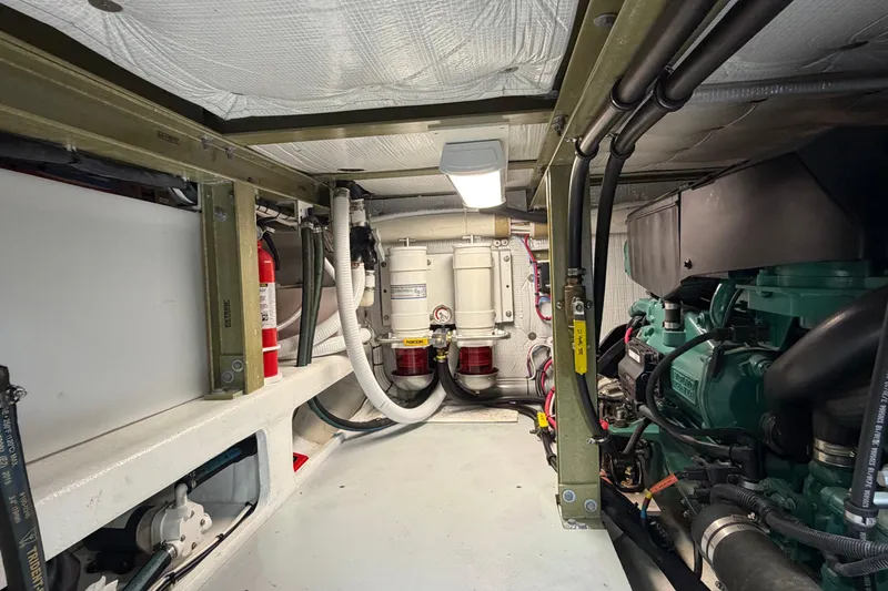Slide: The Image of Engine room of a 2018 H&H Marine Osmond Beal boat, featuring mechanical components and fire extinguisher. - 87