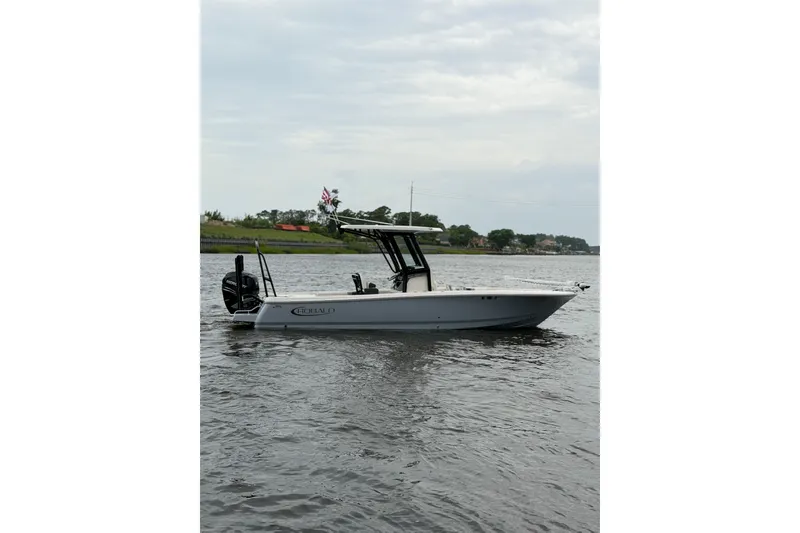 Slide: The Image of 2022 Robalo 266 Cayman boat on calm water under cloudy sky. - 2