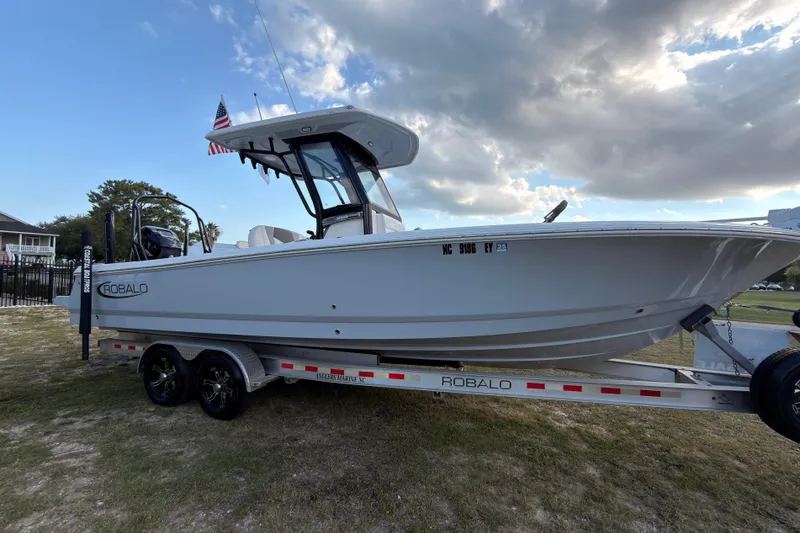 Slide: The Image of 2022 Robalo 266 Cayman boat on trailer under cloudy sky. - 44