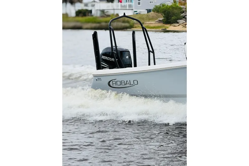 Slide: The Image of A 2022 Robalo 266 Cayman boat cruising on water. A Mercury engine is visible. - 26
