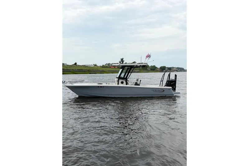 Slide: The Image of 2022 Robalo 266 Cayman boat on calm water, side view with clear sky. - 5