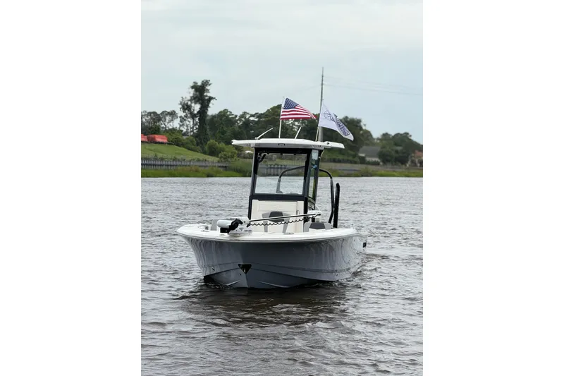 Slide: The Image of 2022 Robalo 266 Cayman boat on water with flags, showcasing sleek design. - 6