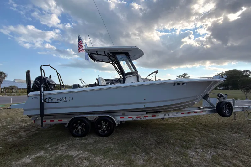 Slide: The Image of 2022 Robalo 266 Cayman boat on trailer under cloudy sky. - 43