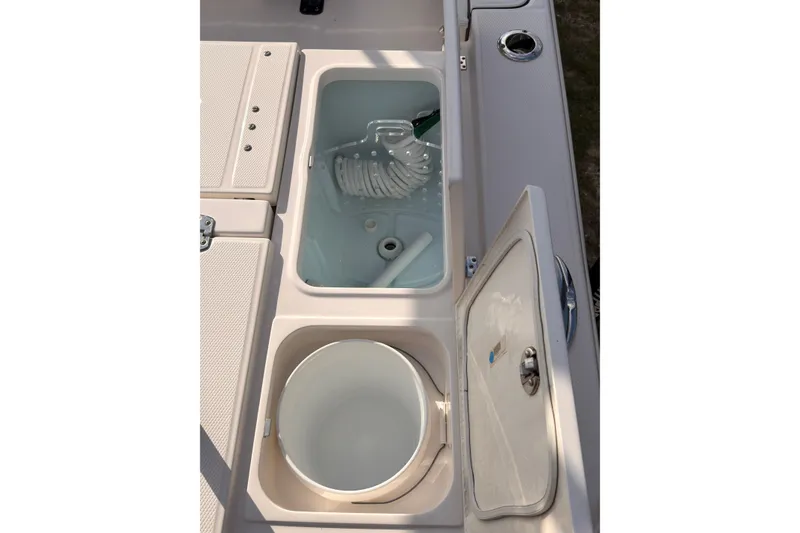 Slide: The Image of 2022 Robalo 266 Cayman boat storage compartments with open lids, showcasing interior features. - 30