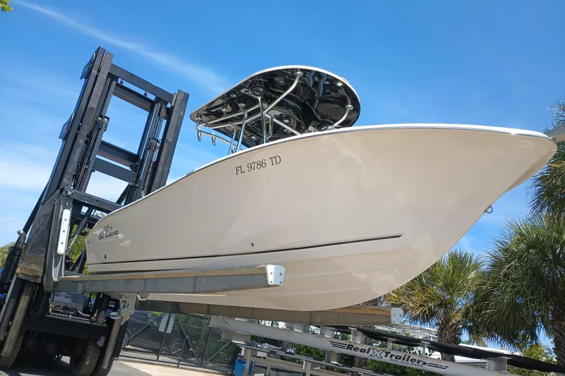 Slide: The Image of 2022 Sea Chaser 22 HFC boat on a trailer, ready for transport under clear blue skies. - 8