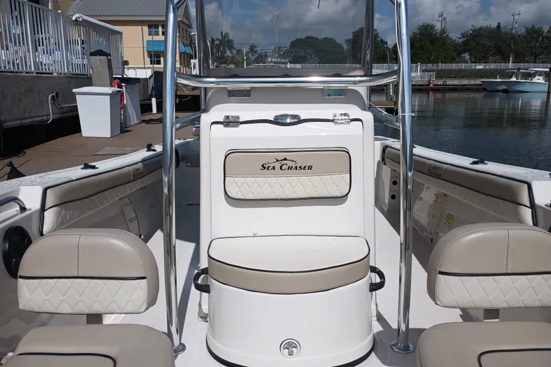 Slide: The Image of 2022 Sea Chaser 22 HFC boat interior with seating and console at a marina. - 19