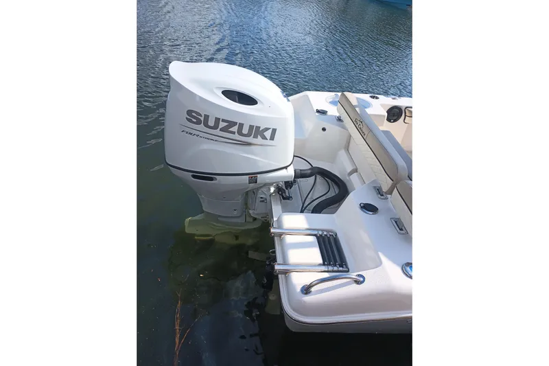 Slide: The Image of 2022 Sea Chaser 22 HFC boat with Suzuki outboard motor on water. - 2