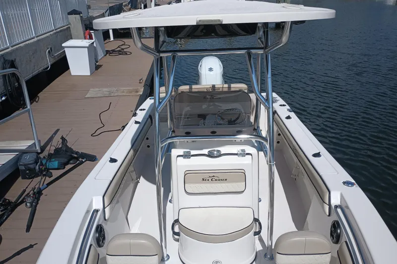 Slide: The Image of 2022 Sea Chaser 22 HFC boat docked, showcasing spacious deck and seating. - 21