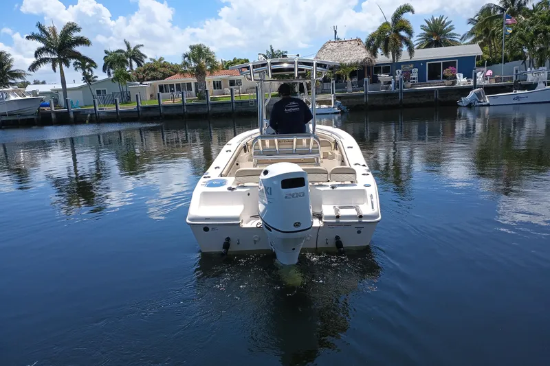 Slide: The Image of 2022 Sea Chaser 22 HFC boat cruising on a calm waterway with palm trees. - 2