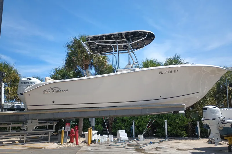Slide: The Image of 2022 Sea Chaser 22 HFC boat with Suzuki engine, docked under a clear blue sky. - 9