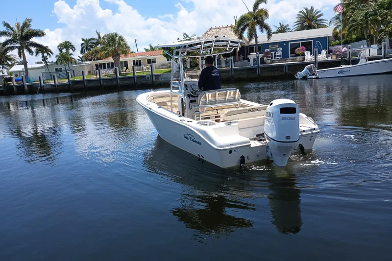 Slide: The Image of 2022 Sea Chaser 22 HFC boat cruising on a calm waterway near palm trees. - 1