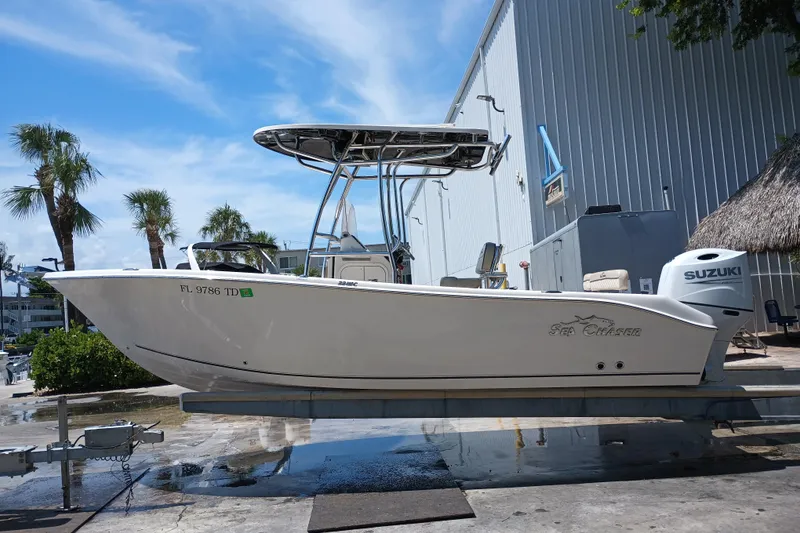Slide: The Image of 2022 Sea Chaser 22 HFC boat with Suzuki engine, parked outdoors near palm trees. - 4
