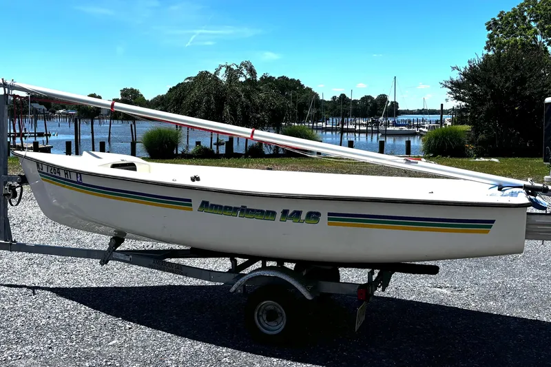 The Image of 2018 American Sail 14.6 sailboat on trailer by a scenic waterfront. - 1