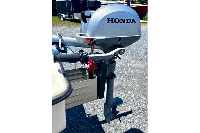 Slide: The Image of Outboard motor on a 2018 American Sail 14.6 boat, parked on gravel. - 10