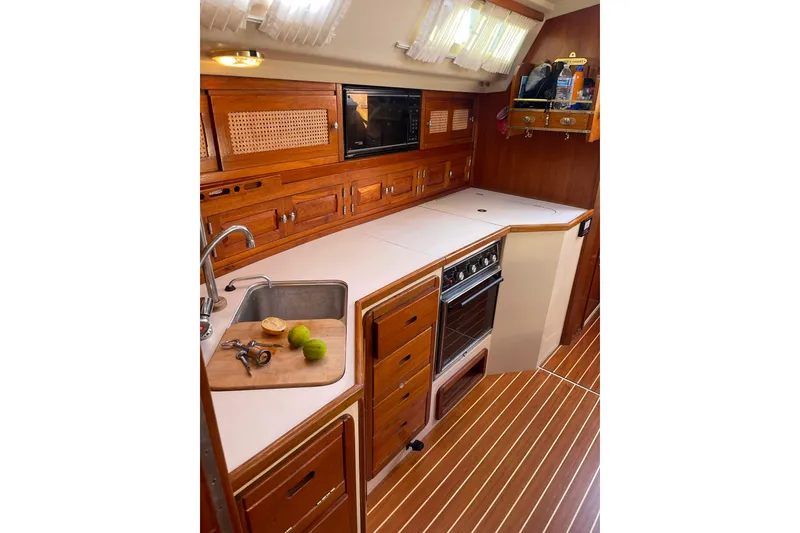 Slide: The Image of Cozy kitchen in 1990 Catalina 42 sailboat with wooden cabinetry and modern appliances. - 11