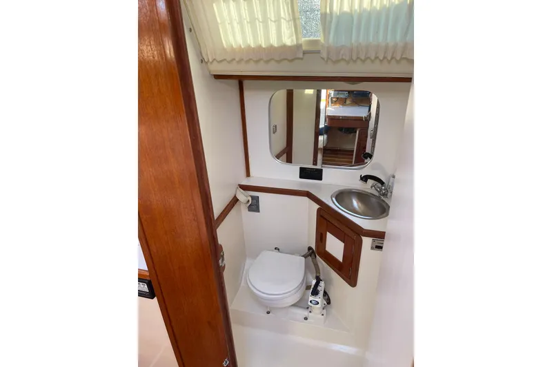 Slide: The Image of Bathroom interior of a 1990 Catalina 42 sailboat, featuring a sink and toilet. - 14