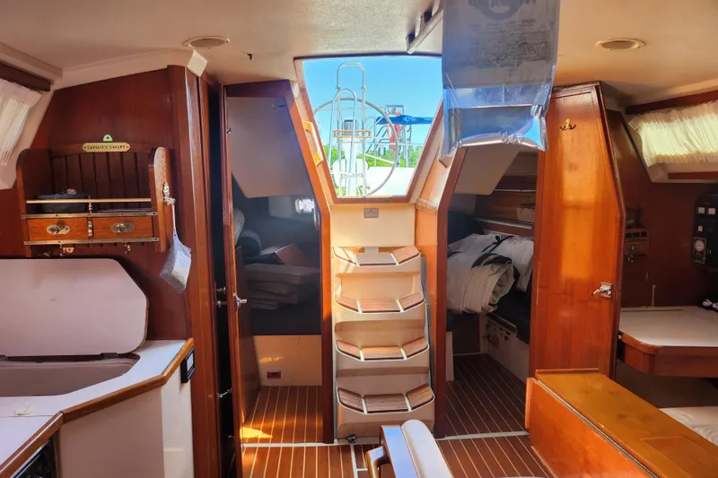 Slide: The Image of Interior of a 1990 Catalina 42 sailboat, featuring wooden cabinetry and cozy sleeping quarters. - 15