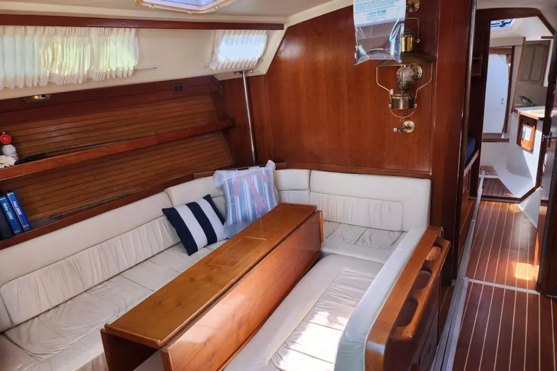 Slide: The Image of Interior of a 1990 Catalina 42 sailboat with wooden furnishings and cozy seating. - 16