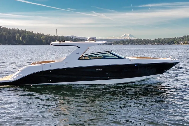 The Image of 2025 Sea Ray SLX 400 luxury boat cruising on a scenic lake with mountain backdrop. - 0