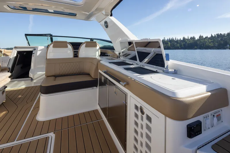 Slide: The Image of 2025 Sea Ray SLX 400 boat interior with luxurious seating and modern amenities on a sunny day. - 29