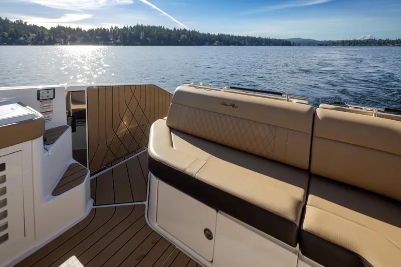 Slide: The Image of 2025 Sea Ray SLX 400 boat interior with tan seating, overlooking a serene lake. - 32