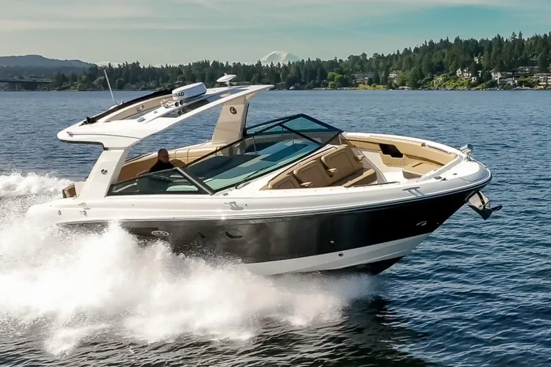 Slide: The Image of 2025 Sea Ray SLX 400 cruising on a scenic lake with lush green shoreline. - 5