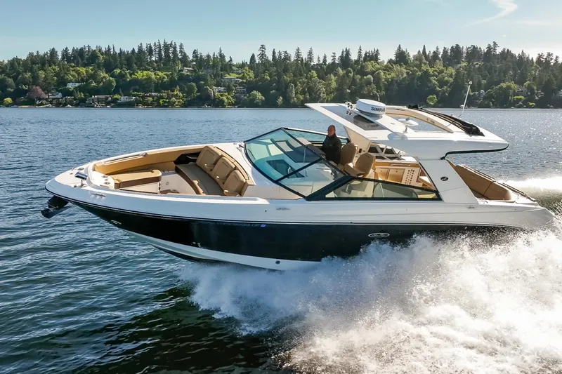 Slide: The Image of 2025 Sea Ray SLX 400 cruising on a scenic lake with lush forest backdrop. - 6