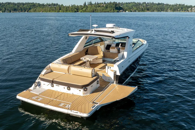 Slide: The Image of 2025 Sea Ray SLX 400 luxury boat on a serene lake, showcasing spacious deck and seating. - 7