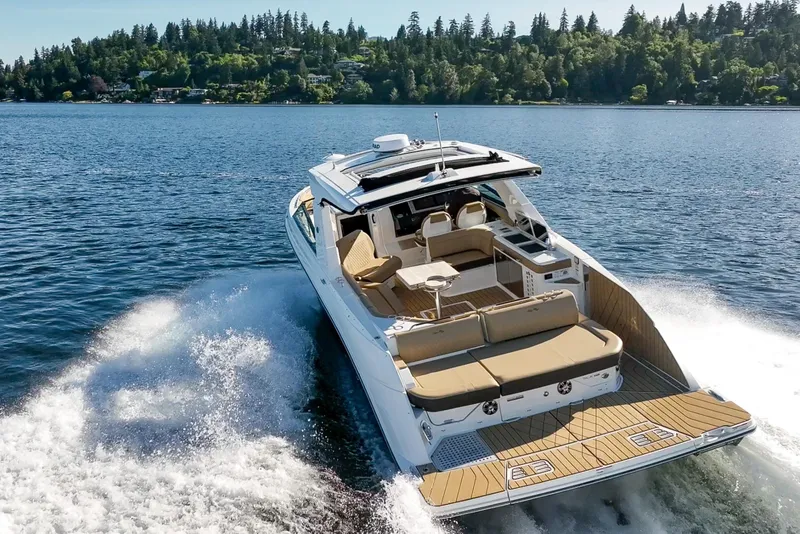 Slide: The Image of 2025 Sea Ray SLX 400 cruising on a scenic lake with lush forested shoreline. - 9