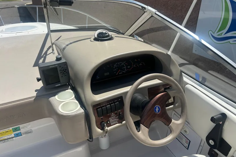Slide: The Image of 1998 Four Winns 258 Vista boat dashboard with steering wheel and navigation instruments. - 10