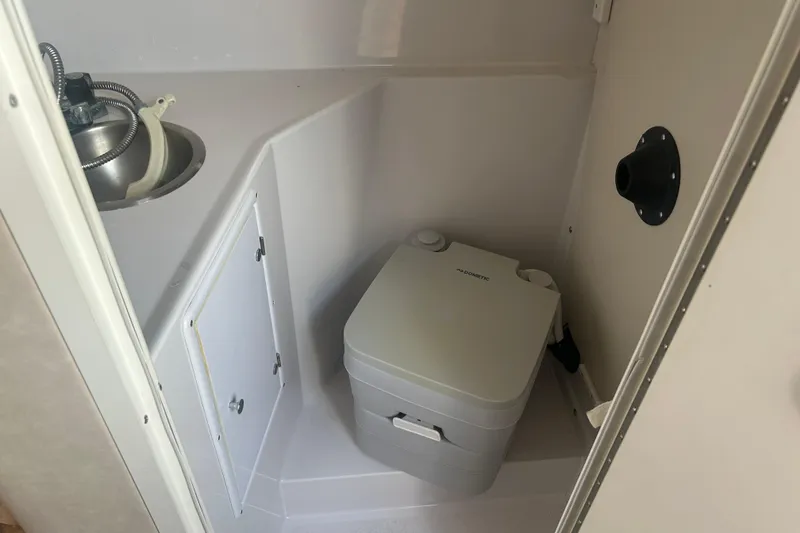 Slide: The Image of 1998 Four Winns 258 Vista boat bathroom with compact sink and portable toilet. - 18