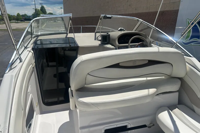 Slide: The Image of 1998 Four Winns 258 Vista boat interior with white seating and steering console. - 8
