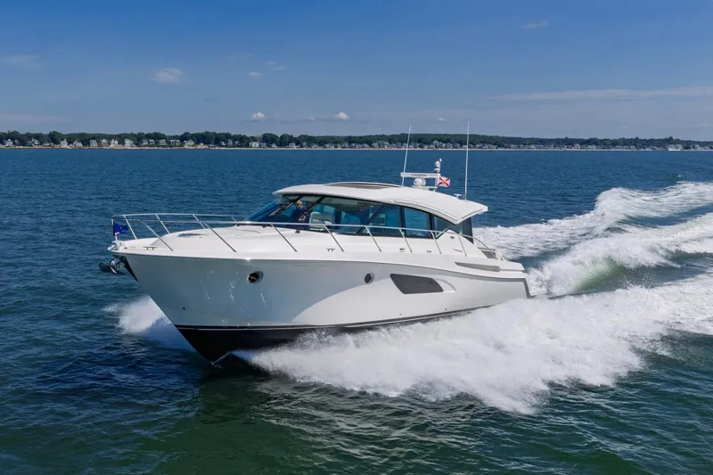 The Image of 2020 Tiara Yachts C53 Coupe cruising on open water, creating waves. - 0