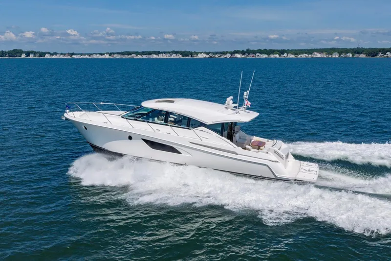 Slide: The Image of 2020 Tiara Yachts C53 Coupe cruising on open water under clear skies. - 1