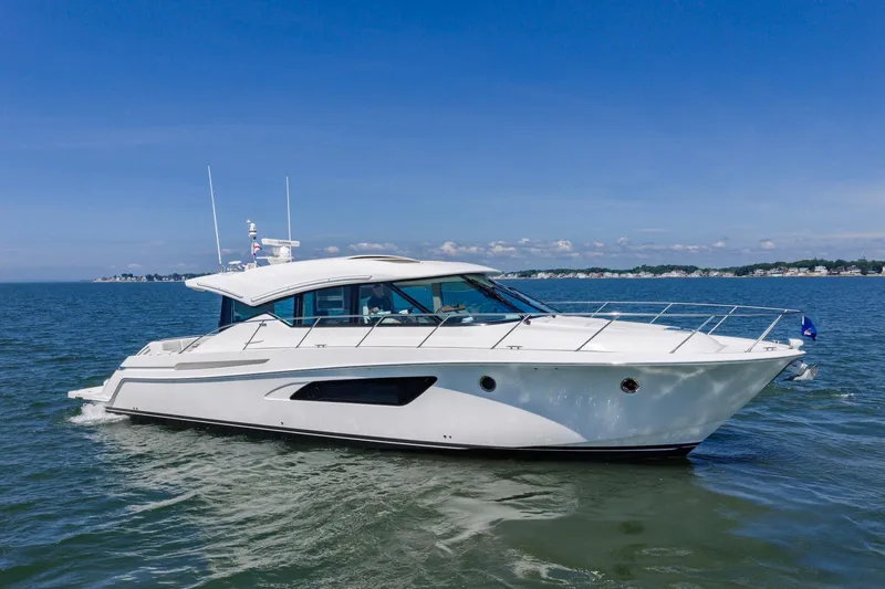 Slide: The Image of 2020 Tiara Yachts C53 Coupe cruising on open water under clear blue skies. - 10