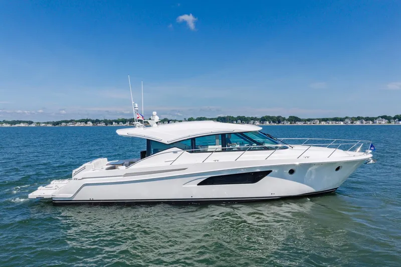 Slide: The Image of 2020 Tiara Yachts C53 Coupe cruising on a sunny day, showcasing sleek design. - 12
