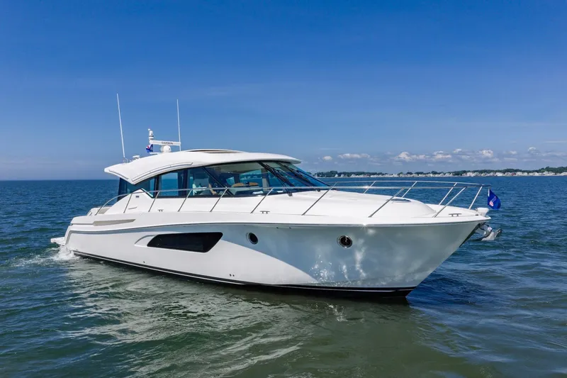 Slide: The Image of 2020 Tiara Yachts C53 Coupe cruising on open water under clear blue skies. - 13
