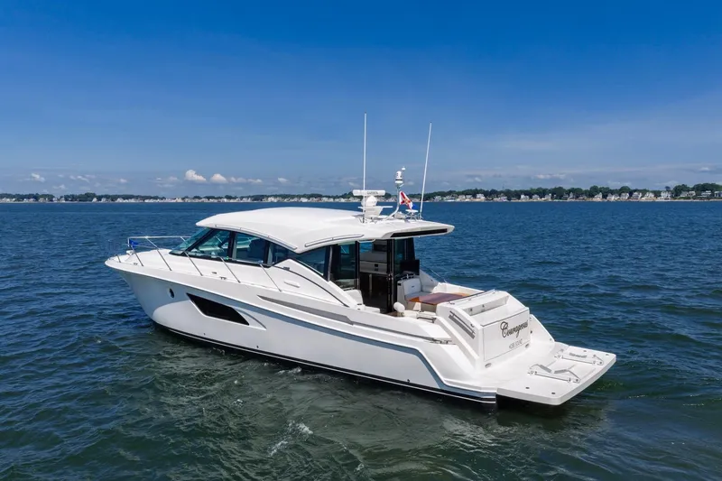 Slide: The Image of 2020 Tiara Yachts C53 Coupe cruising on open water under clear blue skies. - 14