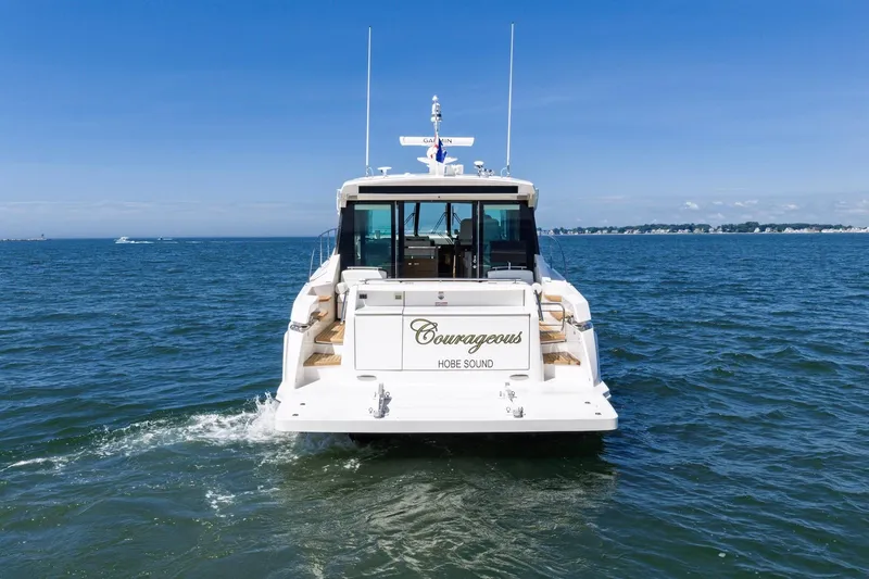 Slide: The Image of 2020 Tiara Yachts C53 Coupe cruising on open water under clear blue skies. - 15