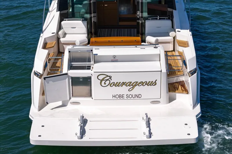 Slide: The Image of 2020 Tiara Yachts C53 Coupe named "Courageous" on water, featuring spacious deck. - 18