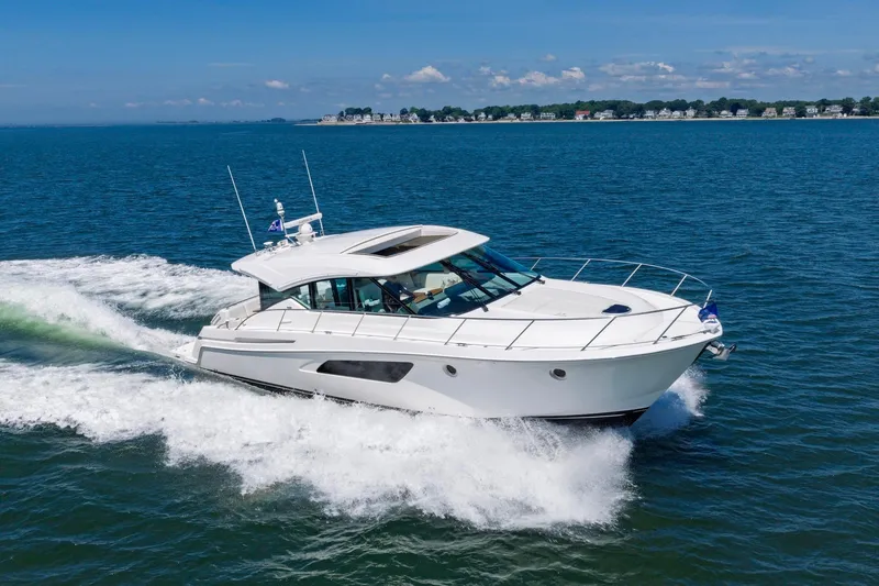 Slide: The Image of 2020 Tiara Yachts C53 Coupe cruising on open water under clear skies. - 2