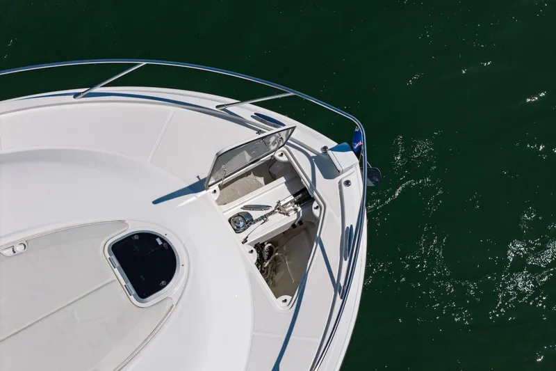 Slide: The Image of Bow of 2020 Tiara Yachts C53 Coupe on water, showcasing sleek design and anchor system. - 23