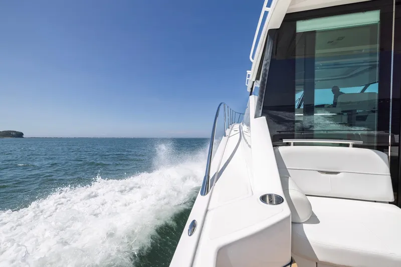 Slide: The Image of 2020 Tiara Yachts C53 Coupe cruising on open water under clear blue skies. - 27