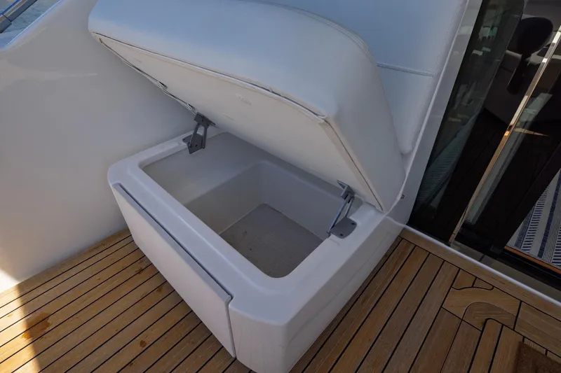 Slide: The Image of Open storage compartment on 2020 Tiara Yachts C53 Coupe with wooden deck flooring. - 33