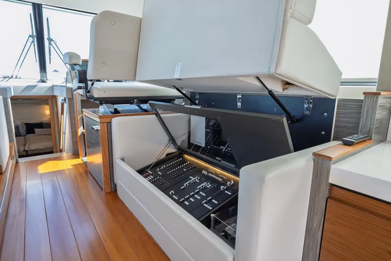Slide: The Image of 2020 Tiara Yachts C53 Coupe interior with open control panel and luxurious seating. - 45
