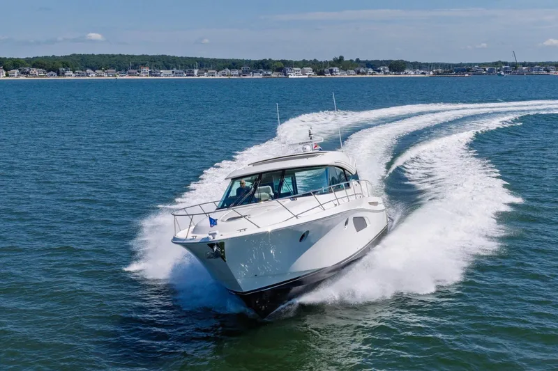 Slide: The Image of 2020 Tiara Yachts C53 Coupe cruising on open water, creating a dynamic wake. - 5